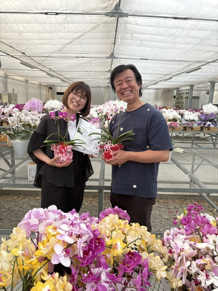 胡蝶蘭を持つ笑顔の夫婦