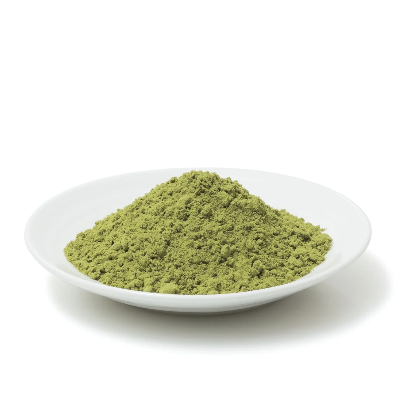 白い皿に盛られた山状の緑色の粉末が写っています。抹茶や緑茶の粉末のように見え、白い背景に置かれています。