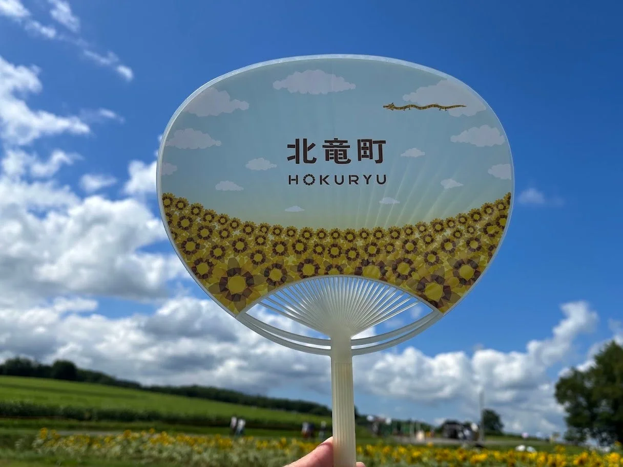ひまわり畑を背景にしたライスレジン製うちわ
