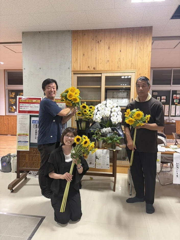 ひまわりの花束を持つ人々