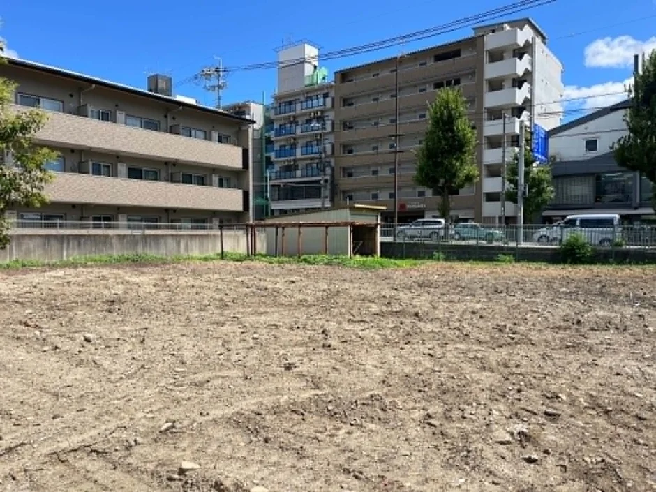 青い空の下、広大な更地が広がる都市の風景